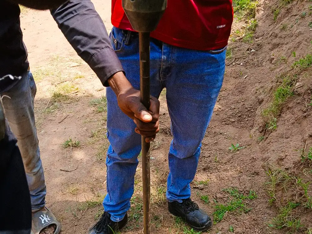 Auger rod and extension sections at the borehole